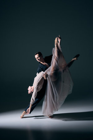 Ballet partners in bold lift with flowing fabric and sculptural silhouette. Concept of strength, romance, editorial elegance, and theatrical performance.の写真素材