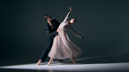 Ballet duet performance with elegant lift, refined balance captured under dramatic light. Concept of art, emotional storytelling, movement, romance, and cultural elegance.の写真素材