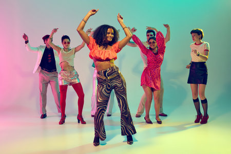 Confident woman in bright top dancing in front of diverse retro group. Concept of youth lifestyle,...