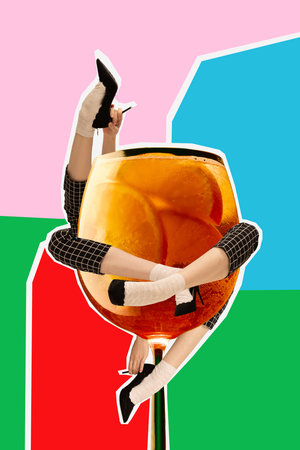 Graphic composition. Woman legs in checkered pants immersed in giant orange cocktail glass. Concept of nightlife, playful surreal fashion, cocktails as art and humorous social creativity.の写真素材