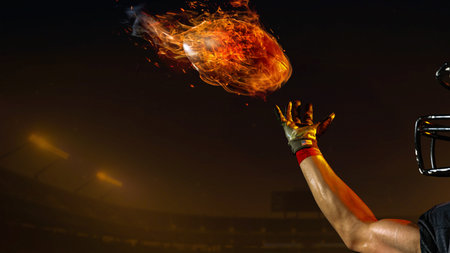 American football ball surrounded by flames flying through night 3D stadium. Concept of power,...