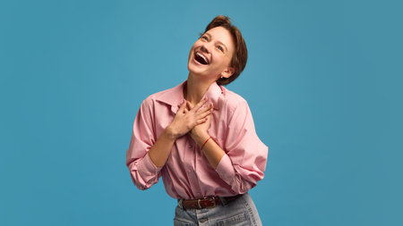 Happy young woman with hands on chest expressing gratitude and joy. Concept of appreciation,...