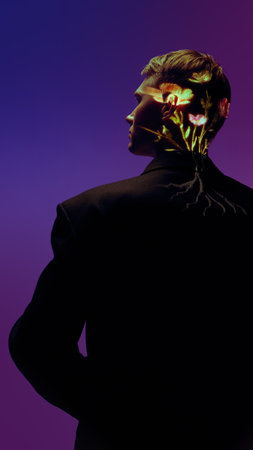 Man in dark suit with glowing botanical light projection on neck under purple light. Concept of inner growth, connection between humanity and technology for modern art and editorial visuals.の写真素材
