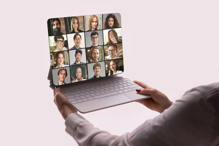 Creative digital artwork. Woman holding laptop during cheerful international video meeting. Concept of digital teamwork, global connection, education, and remote work collaborationの写真素材