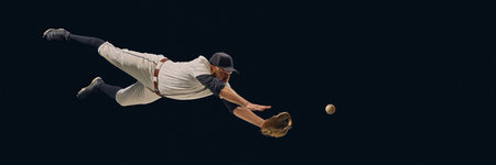 Baseball player diving full stretch catching ball midair. Concept of athletic dedication, fielding precision, professional sports visuals for training and editorial use. Bannerの写真素材