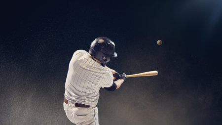 Baseball batter striking ball midair during hit showing timing and reaction focus. Concept of accuracy, athletic power, performance dynamics for motion analysis and sports advertising.の写真素材