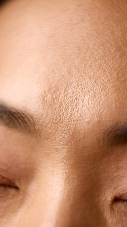 Close macro of forehead skin showing texture moisture and light balance. Concept of skincare education, health observation, and awareness of texture in dermatology visuals.の写真素材