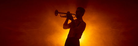 Trumpet player silhouette against warm concert lighting background. Concept of music industry promotion, festivals and clubs visuals, art and graphic design applications. Bannerの写真素材