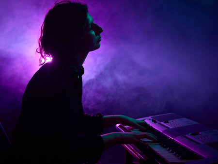 Keyboard player performing on stage with purple haze lighting. Concept of music gear advertising,...