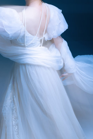 Flowing fabric and pearl strands in gentle motion, soft light and grace. Concept of accessories design, emotional calm, and fashion elegance in expressive visual movement.の写真素材