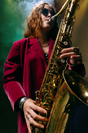 Saxophonist in red jacket and round glasses playing passionately in smoke and light. Concept of music posters, creative advertising, and emotional psychology for visual storytelling.の写真素材