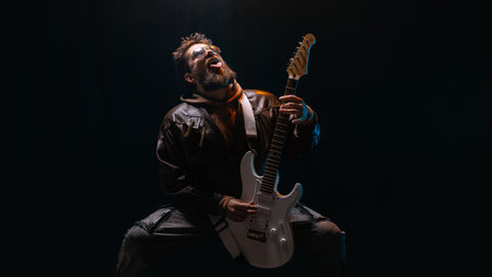 Rock guitarist expressing power and freedom on dark stage with intense emotion. Concept of music psychology, emotional liberation, creativity, and editorial promotion.の写真素材