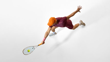 Male tennis player lunging forward for shot showing strong posture and body control. Concept of business leadership, performance focus, goal orientation, and motivational imagery.の写真素材