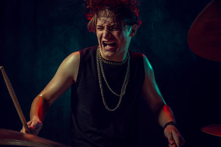 Drummer performing live on stage with passion. Concept of happiness, motivation, emotional health, and artistic confidence.の写真素材