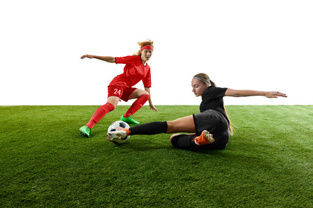 Female football players competing for ball in intense sliding tackle moment. Concept of match coverage, defensive skills training, coaching materials, sports promotion.の写真素材