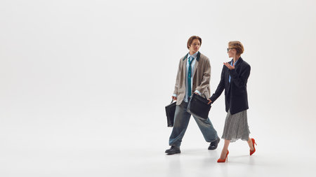 Male and female colleagues walking and discussing ideas representing teamwork and innovation. Concept of collaboration, equality, and business communication in modern workplace culture.の写真素材