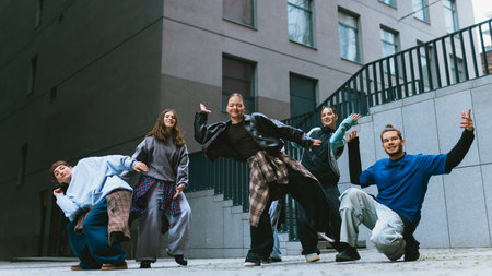 Hip hop group moving in sync during outdoor practice. Concept of coordination skills, group dynamics, active lifestyle promotion, youth training process, modern street culture.の写真素材
