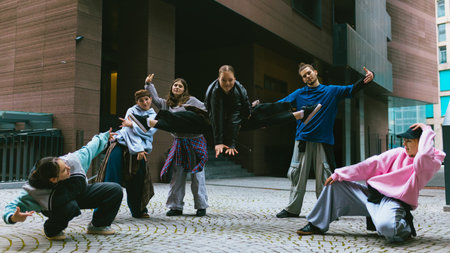 Breakdance group practicing expressive movement in modern city. Concept of dance education, creative...
