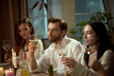 Man holding wine glass during dinner conversation. Concept of wine tasting, premium beverage,...