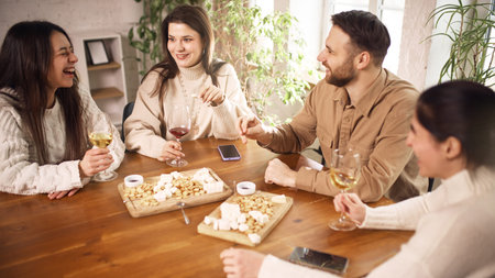 Friends drinking wine together at home table setting. Concept of social lifestyle, hospitality,...