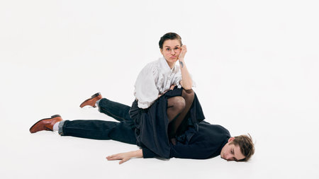 Confident business woman posing while sitting on man in minimal white space. Concept of leadership...