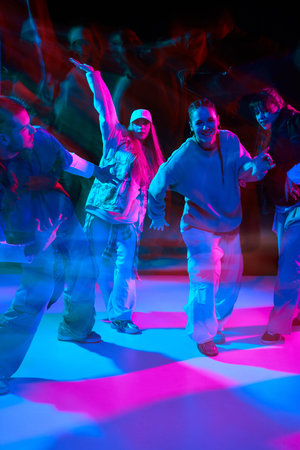 Dance performers doing hip hop street choreography with neon lighting and motion blur for nightlife...