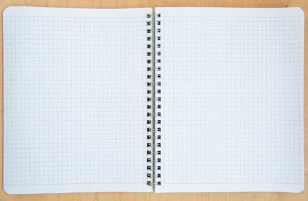open notebook on a wooden background. Open net note pad with a pen on a gray table