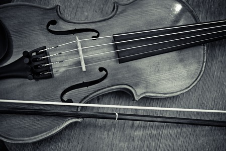 The violin on the table. Black and white horizontal image of the bottom half of violin
