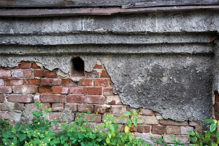 Old brick wall with cracks and scratches. Horizontal wide brickwall background. Distressed wall with broken bricks texture. House facade. fragment of the old, collapsing facade of the houseの写真素材