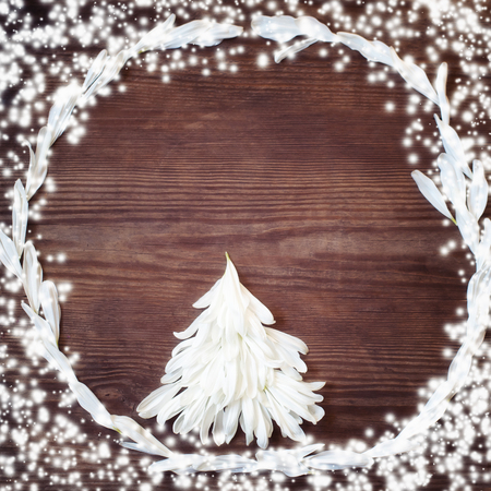 Christmas background with christmas tree of white petal on rustic wooden table. Christmas or New year DIY packing. Holiday decor concept. Overhead, flat lay, top view, copy spaceの写真素材