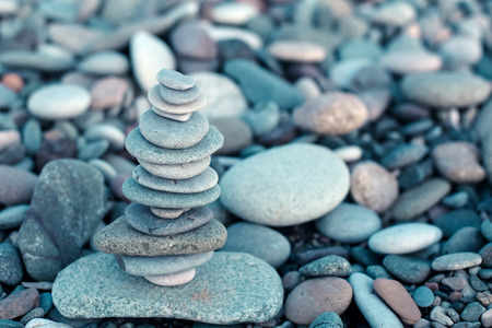 Stack of stones on beach - nature background. Stone cairn on stones background, pebbles and stones....