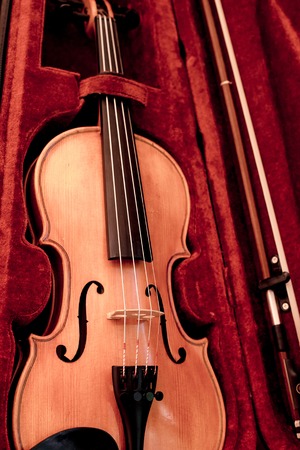 Close up of a violin shallow deep of fieldViolin and bow in dark red case.  Close view of a violin...