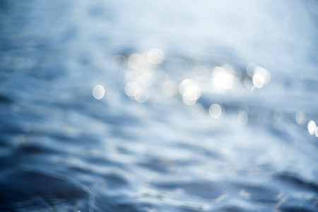 Beautiful underwater sea scene with natural light rays, shining through the water's glittering and blurred bokeh. Natural bokeh blue blur view of water surface backgrounds.の写真素材