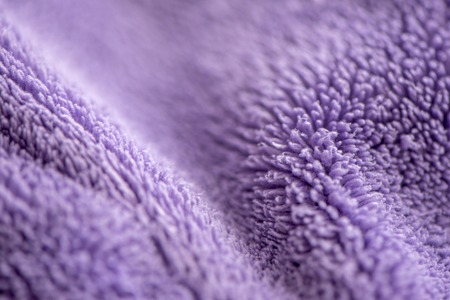 Lilac delicate soft background of fur plush smooth fabric  image. Texture of purple soft fleecy blanket textile photo. Faux fur picture. Soft focus. Shallow depth of fieldの写真素材