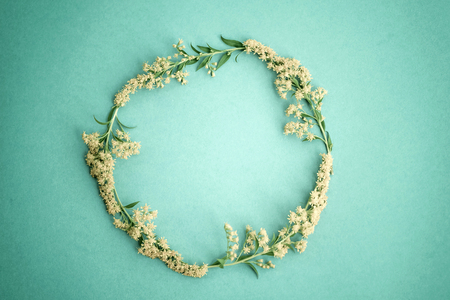 Springtime floral composition picture. Floral round frame made of yellow flowers isolated on paper green background image.  Flat lay, top view, copy space. Black and white photoの写真素材