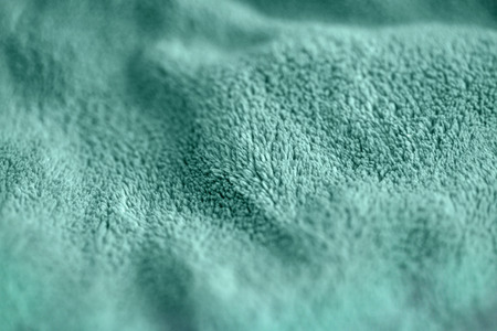 Green delicate soft background of fur warm plush smooth fabric. Texture of turquoise soft fleecy...