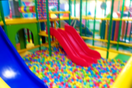 Defocused background.  Modern children playground indoor. Inside the colorful plastic jungle for...