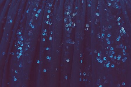 Background sequin. Holiday abstract glitter background with blue blinking lights. Fashion fabric...