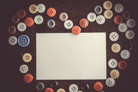 Buttons heart shaped on retro wooden background. Colorful heart background on vintage old surface. Old colorful buttons. Valentines day backgroundの写真素材