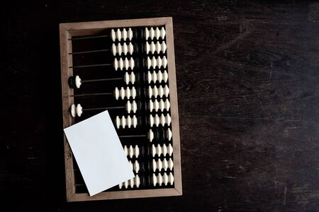 Old accounting scores and white card on a dark antique wooden table. 2020 number