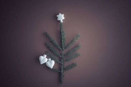 Christmas tree white glass toys two hearts and natural fir branch on paper vintage toned Concept of love, lovers in christmas Art xmas greeting card. vintage toned. Flat lay, top view.の写真素材