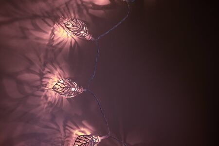 Abstract creative golden christmas garland light on purple dark background with shadow. Concept idea...