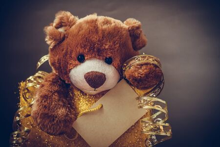 Christmas card with Teddy Bear With a gift and holiday decoration. Christmas Teddy bear holding a place for text and other Christmas decor.の写真素材