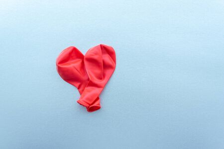Red heart from two new, not inflated Balloons on silver paper background. Copy spaceの写真素材