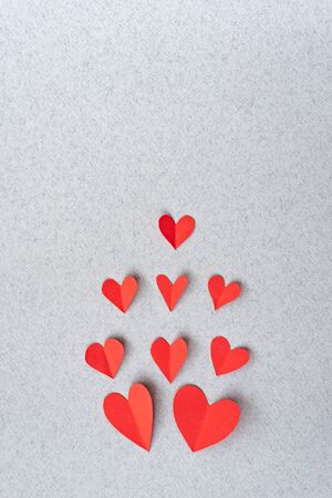 Red heart background Romantic Valentines in love sweet. Red paper hearts on grey textured paper backgrounds. Love and Valentine's day concept.の写真素材