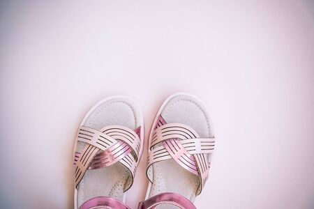 Baby girl pink sandals isolated on white background. Baby fashion pair pink sandals shoes for the toddlers feet close upの写真素材