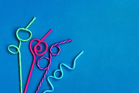 Multicolored Drinking Straws In A Festive Pattern on blue backgroundの写真素材