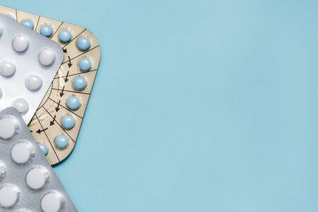 Medicine Pills on on blue backdrop. different color pills of drugs and medicines. Copy space
