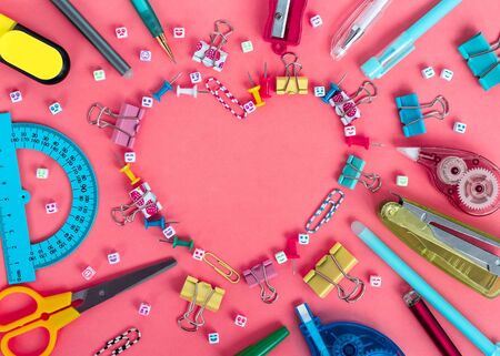 School stationery from heart shaped frame on a pink background. Back to school creative template, copy spaceの写真素材