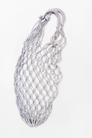 Gray mesh bag on a silver background.  Monochrome image. Top view, flat lay, copy spaceの写真素材